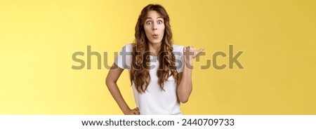 Cutrious interested excited attractive enthusiastic girl gossiping intrigued stare camera thrilled folding lips tempting admiration show thumb left impressive cool thing hold hand waist relaxed. Royalty-Free Stock Photo #2440709733