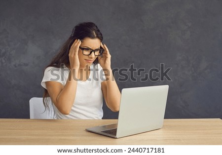 Sad upset millennial Hispanic woman in glasses work on laptop suffer from migraine headache. Unhappy female have problems stressed with gadget operational spam scam. Technology trouble concept.