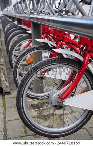 Racks for public bicycle services. red bikes are available for rent. City bike rental. Bicycles in the city. Ecological way of transport. Lots of bikes ready to rent