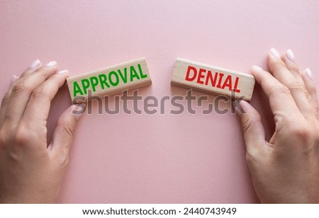 Approval or Denial symbol. Concept word Approval or Denial on wooden blocks. Businessman hand. Beautiful pink background. Business and Approval or Denial concept. Copy space Royalty-Free Stock Photo #2440743949
