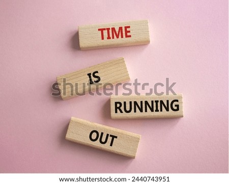 Time is running out symbol. Concept words Time is running out on wooden blocks. Beautiful pink background. Business and Time concept. Copy space.