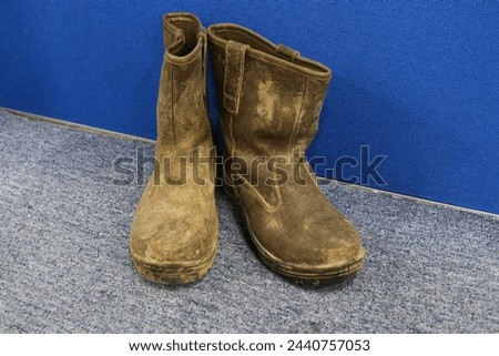 Photo of old shoes that are worn and dirty with mud and dust