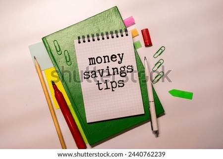 Money Savings Tips, text on small notepad with pen and calculator.