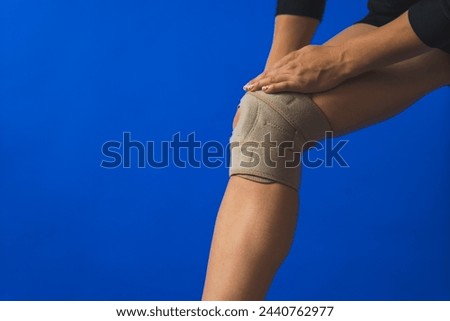 closeup shot of a woman using a protective knee brace to reduce pain, rehabilitation. High quality photo