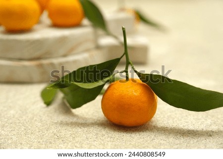 Small orange or tangarine on brown background. Jeruk Royalty-Free Stock Photo #2440808549