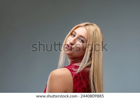 Confident blonde woman playfully poses, exuding charm and liveliness Royalty-Free Stock Photo #2440809885