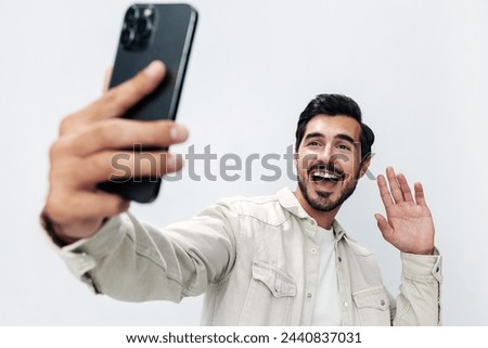 Close-up portrait man with a phone in his hands makes a selfie blogger smile open mouth surprise on a white isolated background, fashionable clothing style, copy space, space for text