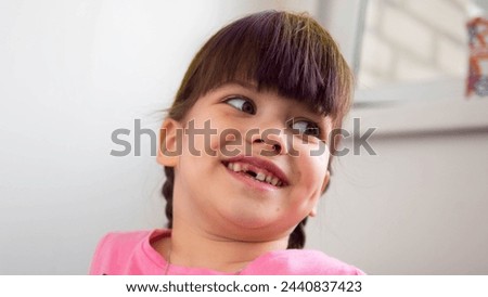 Close up portrait of a happy laughing girl without teeth enjoying good mood on light background