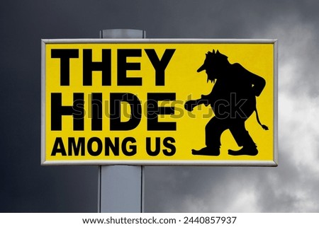 Close-up on a yellow billboard against a cloudy sky with the message "They hide among us" written in the middle next to a troll.
