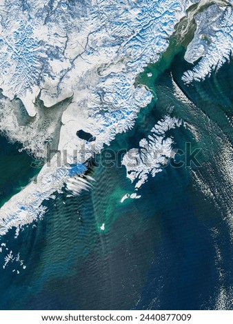 Gravity waves across a streamer of snow off Alaska. . Elements of this image furnished by NASA. Royalty-Free Stock Photo #2440877009