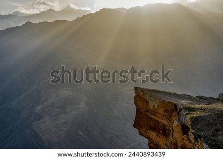 Picturesque mountain landscape at sunset. Rock against amazing scenery with mountain ridge in sunlight. Troll tongue location in Goor, Dagestan, Russia. Wonderful caucasian nature, awesome scenery Royalty-Free Stock Photo #2440893439