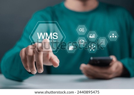 WMS, Warehouse Management System concept. Develop warehouse system management and increase efficiency of work in warehouses. Businessman touching WMS icons on virtual screen. Royalty-Free Stock Photo #2440895475
