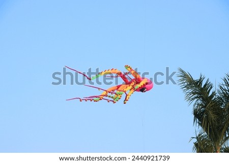 Colorful kites flying in the clear blue sky in summer at Mekong Delta Vietnam. Happy childhood moments.