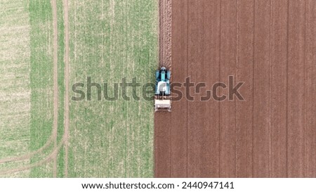 agricultural tractor plowing fields in spring