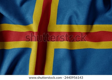 National Flag on Textured Fabric Background. Silk textured flag, realistic wave and flag look. AX  Flag of Åland