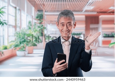 Middle-aged businessman using a smartphone with a smile on his face.
