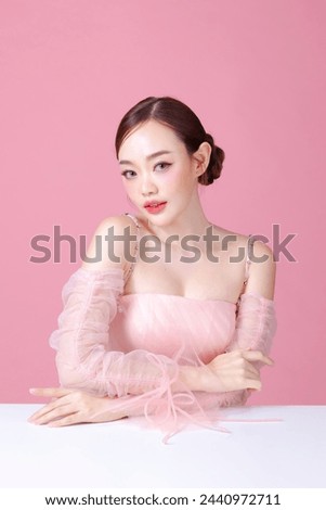 Beautiful young Asian woman model bun hair with natural makeup on face clean fresh skin on isolated pink background. Cute girl portrait, Facial treatment, Valentine concept. Royalty-Free Stock Photo #2440972711