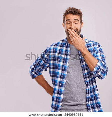 Hand cover mouth, yawn and man with burnout, tired and low energy on a grey studio background. Person, mockup space and exhausted with model and fatigue with emoji, sleepy and lazy with bored gesture Royalty-Free Stock Photo #2440987351