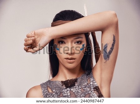 Portrait, woman and Native American girl in studio with warrior makeup, confidence and tribe style. Indigenous fashion, face paint and model in First Nations clothes on white background with culture