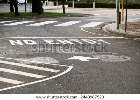 Road marking, no entry and warning with text, arrow and error for direction with paint on asphalt in city. Ground, street and mistake with language, funny typo and comic joke with symbol in Cape Town Royalty-Free Stock Photo #2440987523