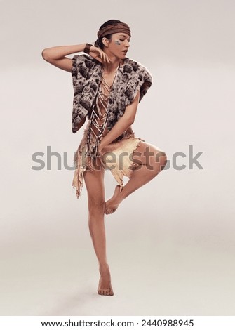 Dance, woman and Native American culture in studio with warrior makeup, confidence and tribe style. Indigenous fashion, ceremony or girl in First Nations clothes on white background with energy