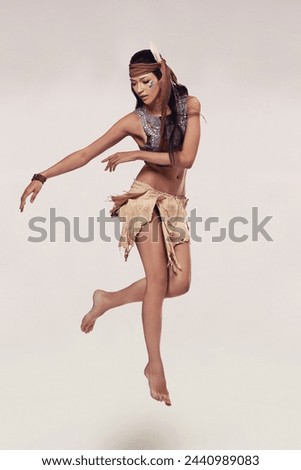Dance, woman and Native American fashion in studio with warrior makeup, confidence and tribe style. Indigenous culture, performance or girl in First Nations clothes on white background with jump