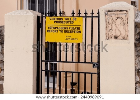Sign, outdoor and warning with gate, building and authority with board and street with design. Notice, urban town and outside with road or safety with protection and review with information or poster
