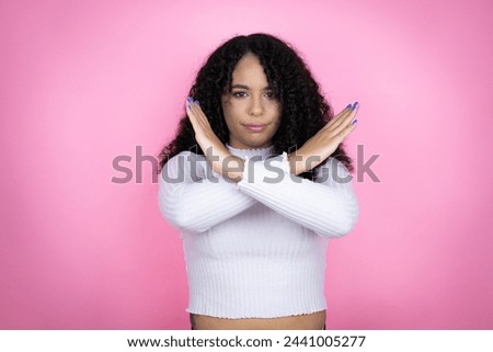 African american woman wearing casual sweater over pink background Rejection expression crossing arms doing negative sign, angry face Royalty-Free Stock Photo #2441005277