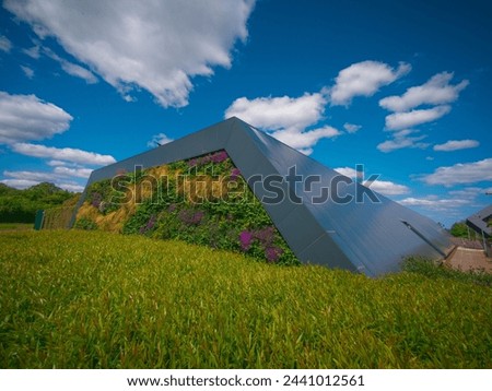 Sustainable Data Centre planted with colourful summer flowers under a gorgeous blue sky with whispy clouds Royalty-Free Stock Photo #2441012561