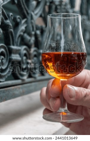 Tasting of aged in barrels cognac alcohol drink and view on old streets and houses in town Cognac, Grand Champagne, Charente, strong spirits distillation industry, France Royalty-Free Stock Photo #2441013649