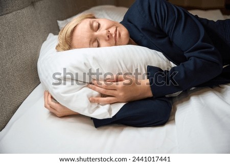 Exhausted businesswoman sleeping peacefully in her bedchamber Royalty-Free Stock Photo #2441017441