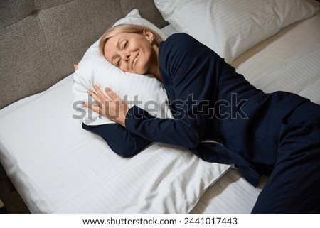 Dozy business lady is resting in her bedchamber Royalty-Free Stock Photo #2441017443