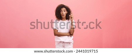 I got excellent idea listen. Portrait of excited charming and creative dark-skinned young woman with afro hairstyle in casual outfit raising index finger in eureka gesture and talking explaining plan Royalty-Free Stock Photo #2441019715