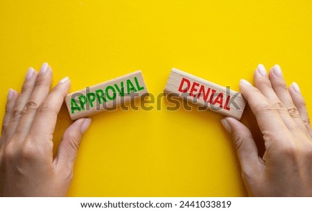 Approval or Denial symbol. Concept word Approval or Denial on wooden blocks. Businessman hand. Beautiful yellow background. Business and Approval or Denial concept. Copy space Royalty-Free Stock Photo #2441033819