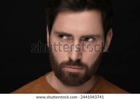 Evil eye. Man with scary eyes on black background, closeup