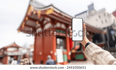 Asian woman hand using mobile phone taking selfie during travel Sensoji Temple at Asakusa district, Tokyo, Japan. People enjoy outdoor lifestyle travel tradition city street on holiday vacation.