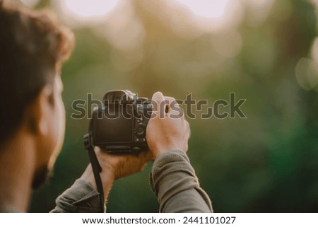 a man taking photography by digital mirrorless camera, nature photographer, selective focus 

