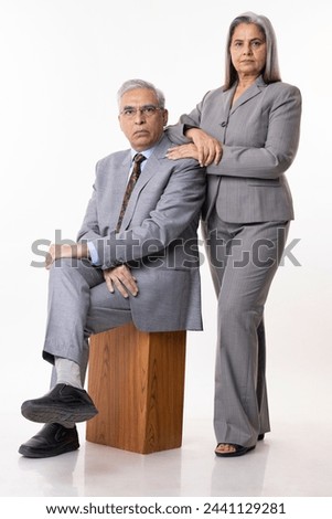 Happy senior businessman and businesswoman standing against white background