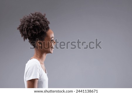 Beaming with delight, her profile captures the essence of joy, natural curls accentuating her vivacity Royalty-Free Stock Photo #2441138671