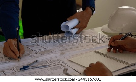 Team of engineers discussing architecture plan sketch at the construction site.