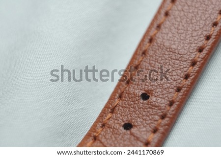 The watch strap is wrinkled brown, with a white background