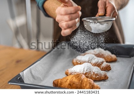 Close-Up of Chef's Hand Sprinkling Powdered Sugar on Croissants with Sieve in Kitchen in 4K Ultra HD Resolution - Stock Photography