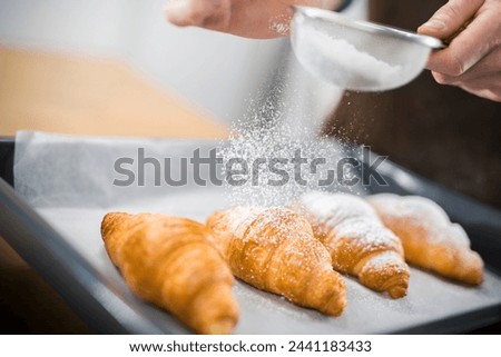Close-Up of Chef's Hand Sprinkling Powdered Sugar on Croissants with Sieve in Kitchen in 4K Ultra HD Resolution - Stock Photography