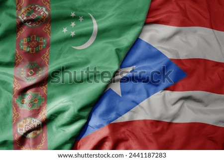 big waving national colorful flag of puerto rico and national flag of turkmenistan. macro