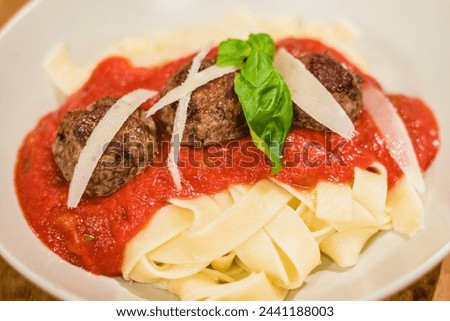 Meatballs and Flat Pasta Served with Sauce and Basil in 4K Ultra HD Resolution - Stock Photography