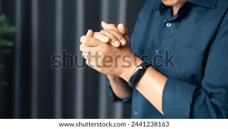 Woman with hands clasped praying while sitting at desk in office. Businesswoman praying at work. Contemplative prayer thinking in office. Hands folded in prayer gesture beg about something.