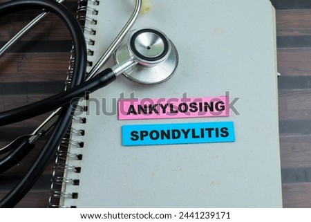 Concept of Ankylosing Spondylitis write on sticky notes with stethoscope isolated on Wooden Table.