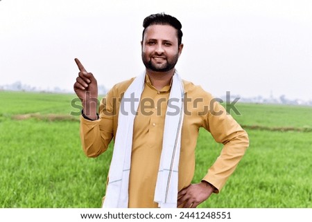 Indian farmer showing finger at agriculture field