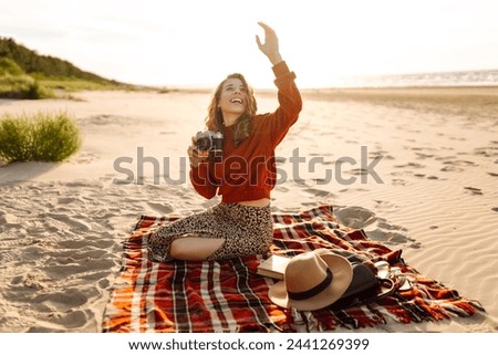 Young woman walking at the beach and taking photos captures the beauty of nature. Travel blog. Adventure, vacation concept.