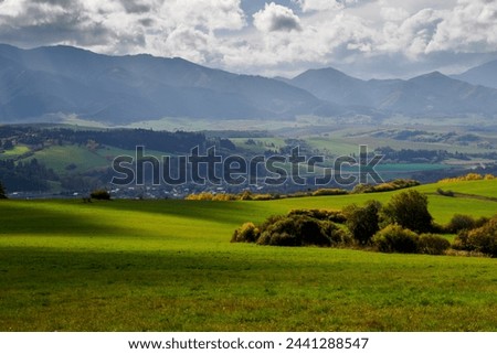 Mountain landscape. In the foreground, a farmland and autumn trees. In the distance you can see the Low Tatras Zilina Region. Beszeniowa. Slovakia.